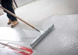 Spreading commercial epoxy flooring during installation in Texas